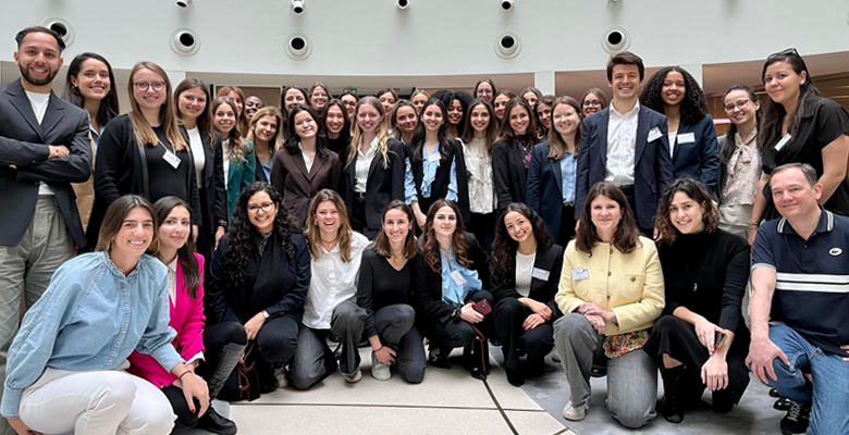 Group photo of diverse women and men from the previous “OWn Your Future” event, gathered together in a bright, modern space, showcasing their community and shared experience.