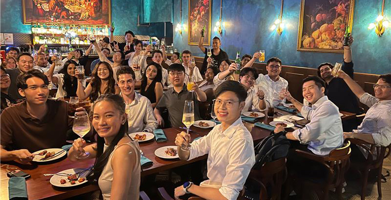 APR Team enjoying dinner in a warmly lit restaurant.