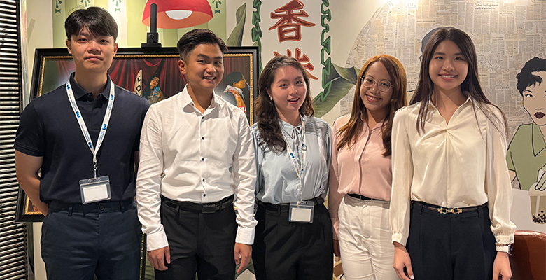 Interns posing in a decorated office setting during the Hong Kong intern day.