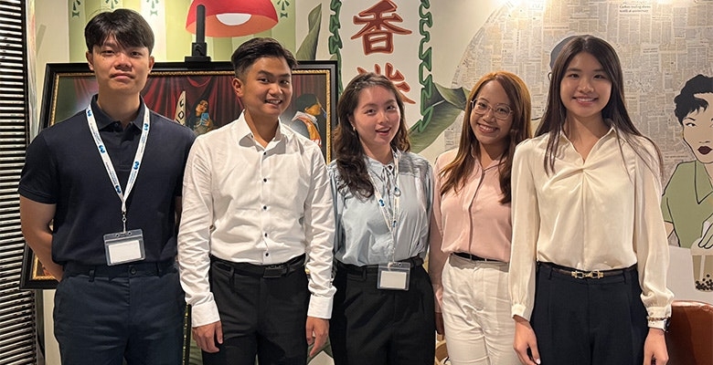 Interns posing in a decorated office setting during the Hong Kong intern day.