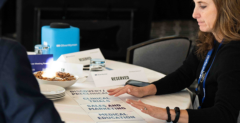 Photography of a woman organizing cards with life sciences topics over a table.