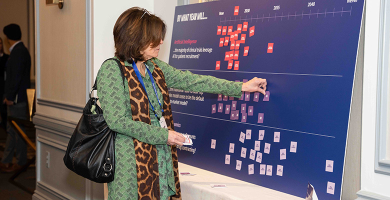 Photography of a woman pasting a sticky note in a colorful board.