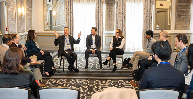 Photography of women and men attending a formal roundtable discussion.