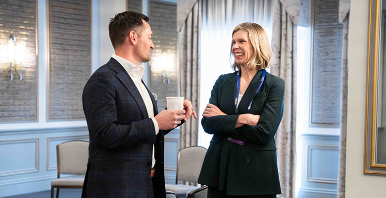 Photography of a man and a woman with formal clothes having a casual conversation.