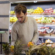 Man comparing apples in a grocery store