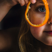 Girl is looking through orange skin